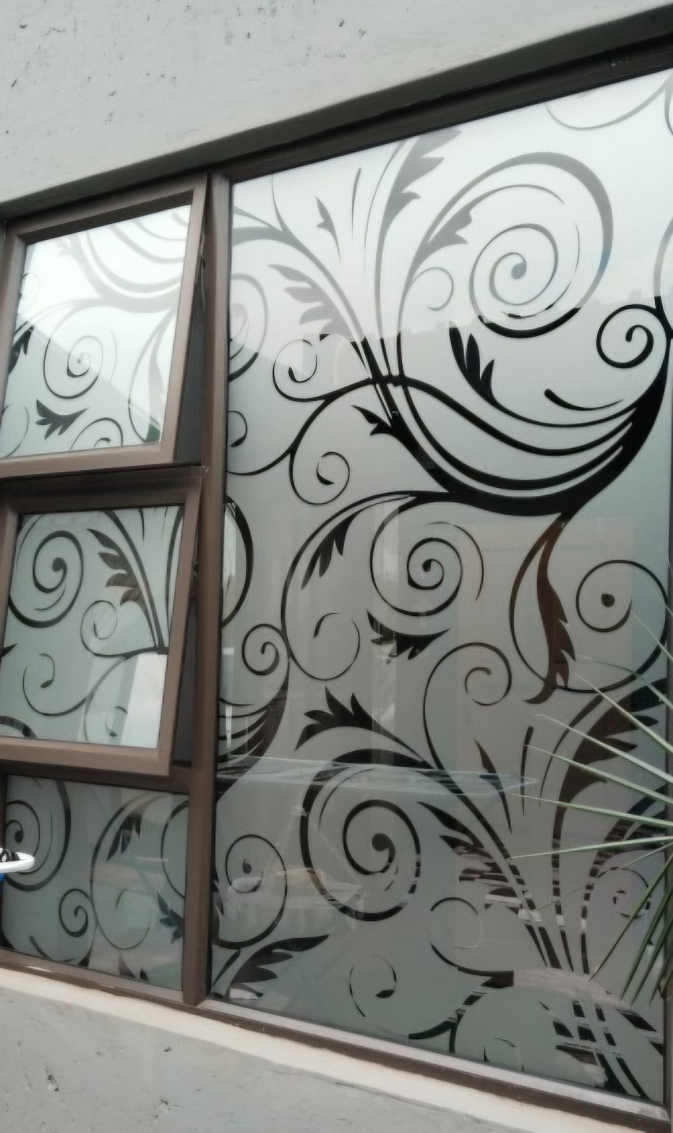 Elegant decorative window frosting with floral scroll pattern on office glass